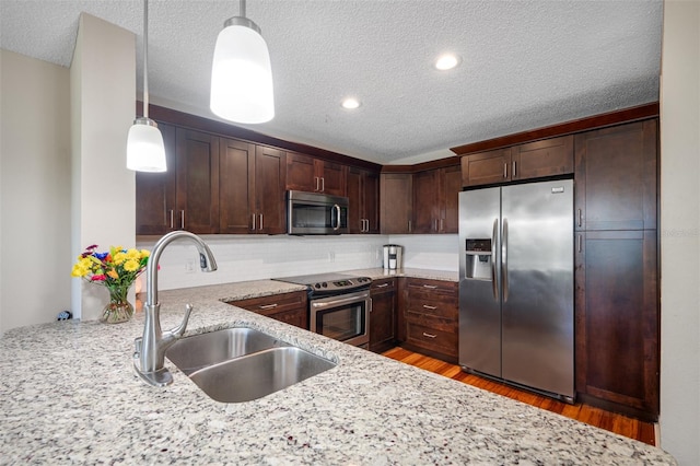 kitchen with dark hardwood / wood-style flooring, stainless steel appliances, light stone countertops, and tasteful backsplash