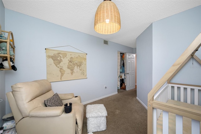 sitting room with carpet flooring and a textured ceiling