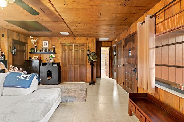 living room featuring wood ceiling and wood walls