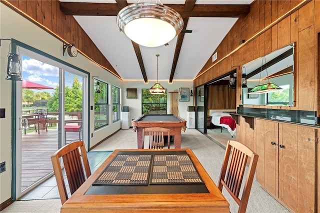 carpeted dining room with pool table, lofted ceiling with beams, and wood walls