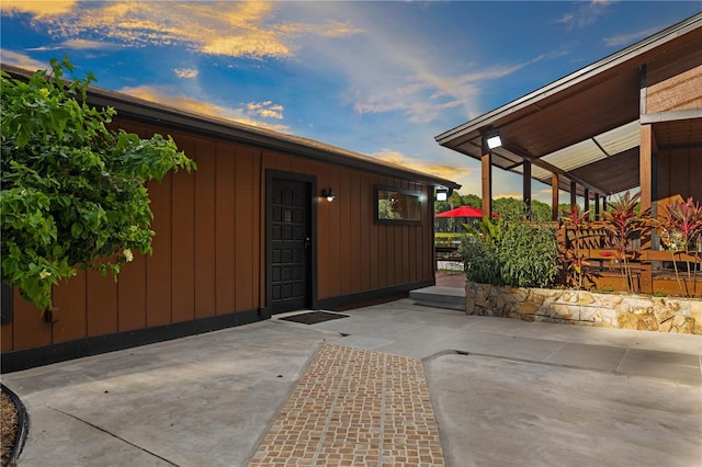 exterior entry at dusk featuring a patio area