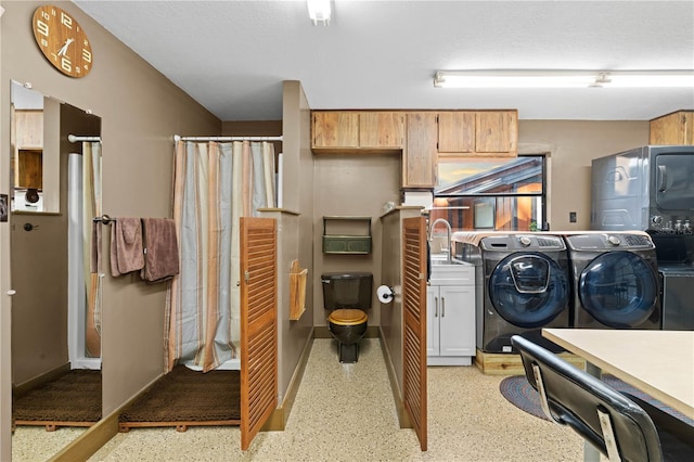 clothes washing area featuring independent washer and dryer and sink