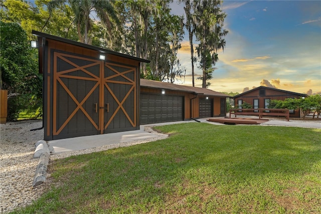 yard at dusk featuring a garage