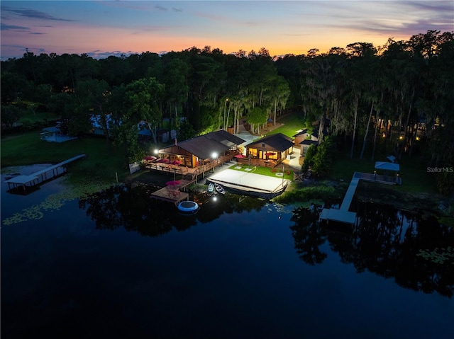 aerial view at dusk featuring a water view