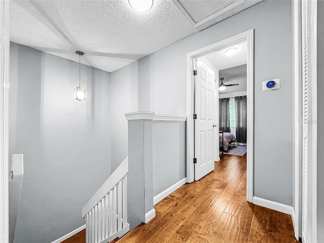 hall featuring hardwood / wood-style floors and a textured ceiling