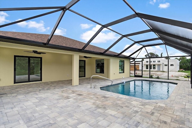 view of pool featuring ceiling fan, glass enclosure, and a patio