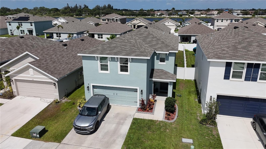 view of front of home featuring a garage, a residential view, concrete driveway, and stucco siding