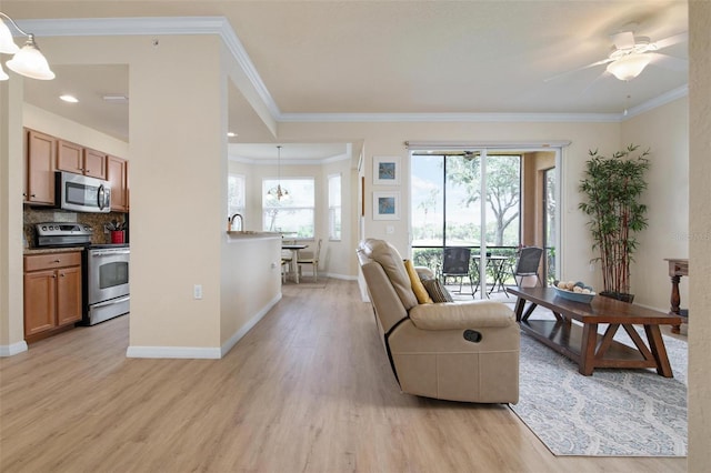 living room featuring ornamental molding, light hardwood / wood-style floors, and ceiling fan