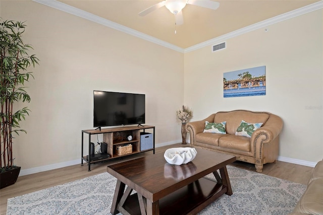 living room featuring ceiling fan, ornamental molding, and light hardwood / wood-style flooring