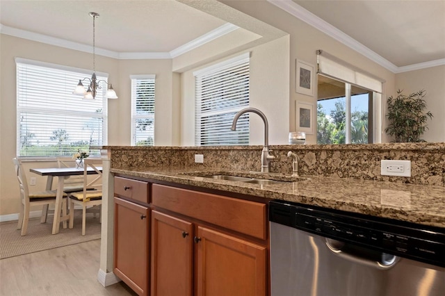 kitchen featuring sink, decorative light fixtures, light wood-type flooring, stainless steel dishwasher, and dark stone counters