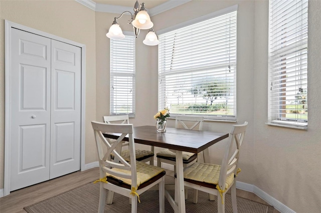 dining space featuring crown molding, a notable chandelier, and hardwood / wood-style flooring