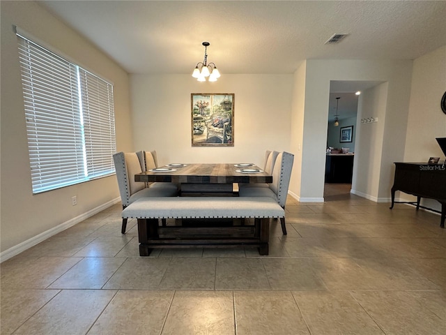 tiled dining area with a notable chandelier