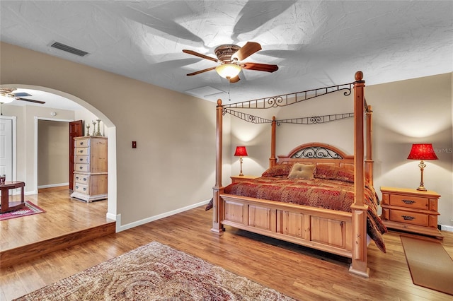 bedroom with wood-type flooring, a textured ceiling, and ceiling fan