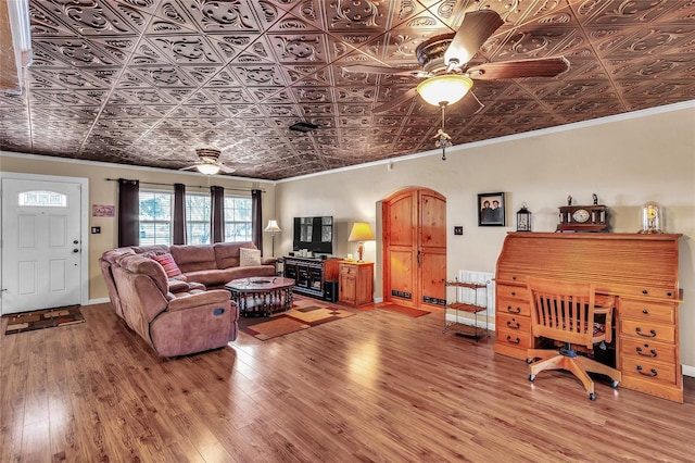 living room featuring hardwood / wood-style flooring, ceiling fan, and crown molding