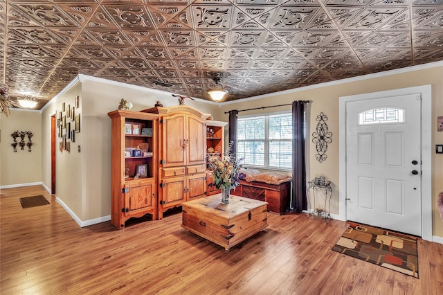 foyer featuring ornamental molding and light wood-type flooring