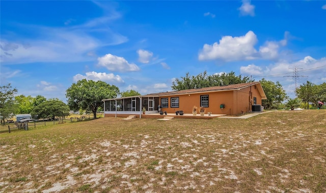 back of house with a lawn, a sunroom, and a patio