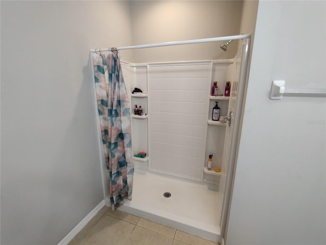 bathroom with a shower with curtain and tile patterned flooring