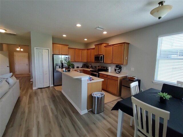 kitchen with a kitchen island, stainless steel appliances, and light wood-type flooring