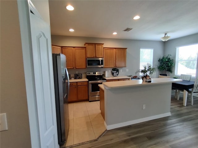 kitchen with a center island, light wood-type flooring, and appliances with stainless steel finishes