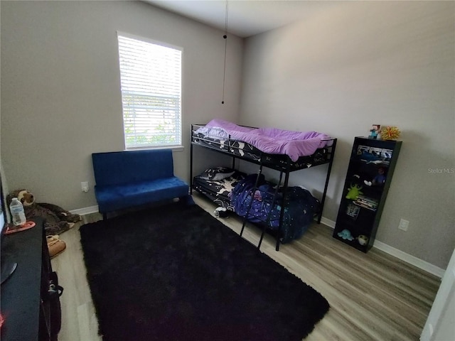 bedroom with hardwood / wood-style flooring and multiple windows