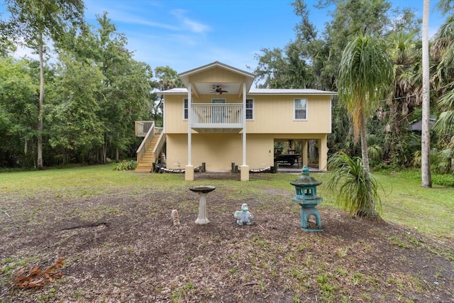 back of property with ceiling fan and a lawn