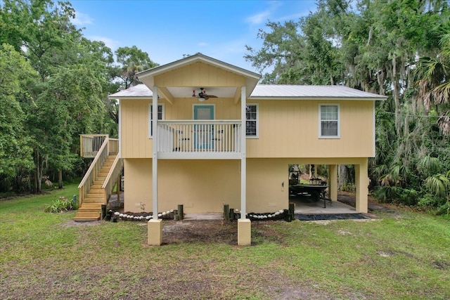 back of property with a yard, a patio area, and ceiling fan