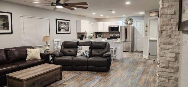 living room with hardwood / wood-style flooring, ceiling fan, and sink