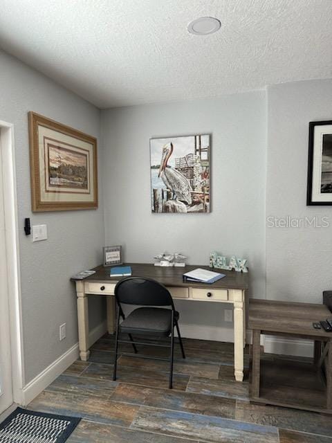 home office featuring dark hardwood / wood-style flooring and a textured ceiling