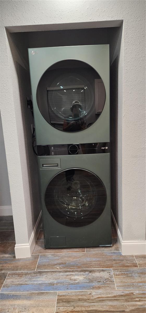 washroom featuring stacked washer / drying machine