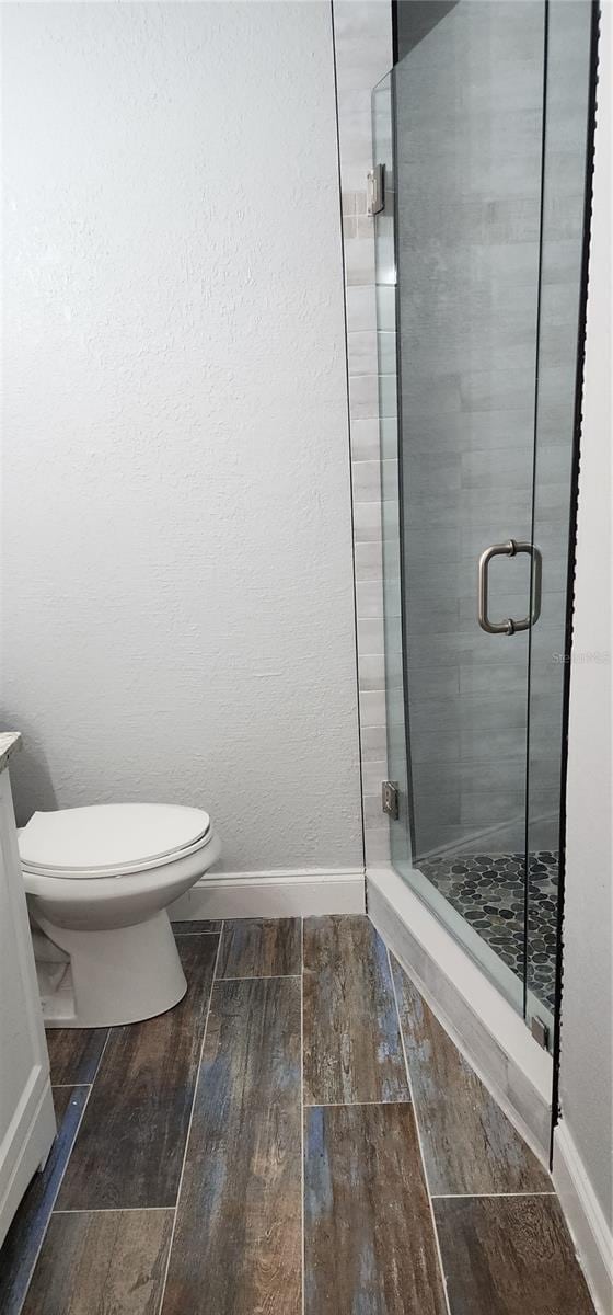 bathroom featuring walk in shower and toilet