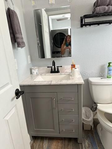 bathroom featuring wood-type flooring, vanity, and toilet