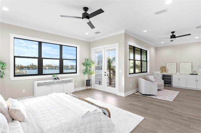 bedroom with beverage cooler, a water view, visible vents, and access to exterior