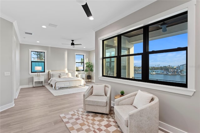 bedroom with visible vents, a water view, crown molding, light wood-type flooring, and recessed lighting