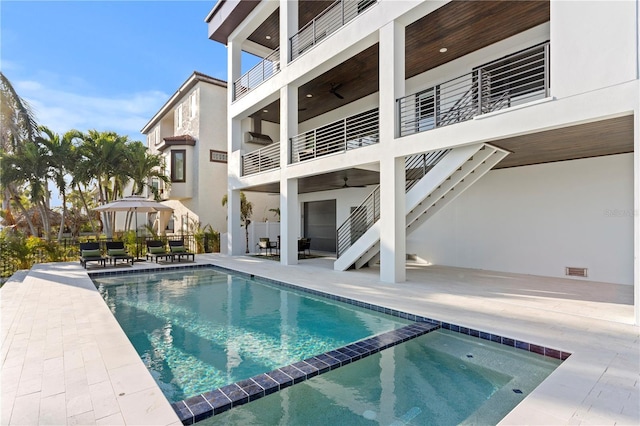 view of swimming pool with a pool with connected hot tub, stairs, and a patio