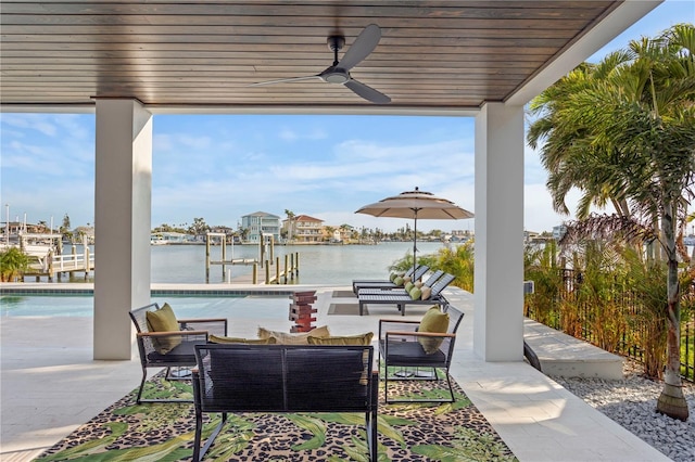 view of patio / terrace featuring an outdoor pool, ceiling fan, boat lift, an outdoor hangout area, and a water view