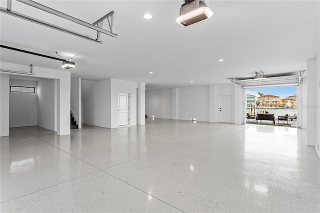 garage featuring recessed lighting, a water view, and a garage door opener