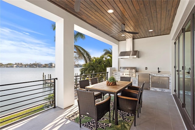 view of patio / terrace featuring area for grilling, outdoor dining area, a water view, and a ceiling fan