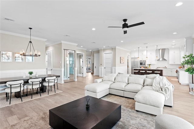 living area with a wainscoted wall, light wood finished floors, visible vents, and recessed lighting