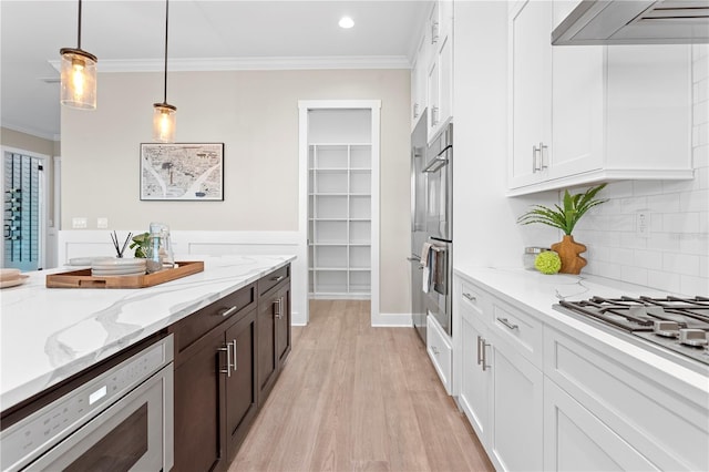 kitchen with light stone countertops, white cabinets, and extractor fan