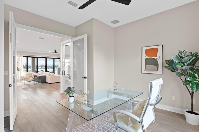 office area featuring light wood-style floors, baseboards, visible vents, and a ceiling fan