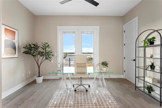 home office featuring a ceiling fan, baseboards, and light wood finished floors