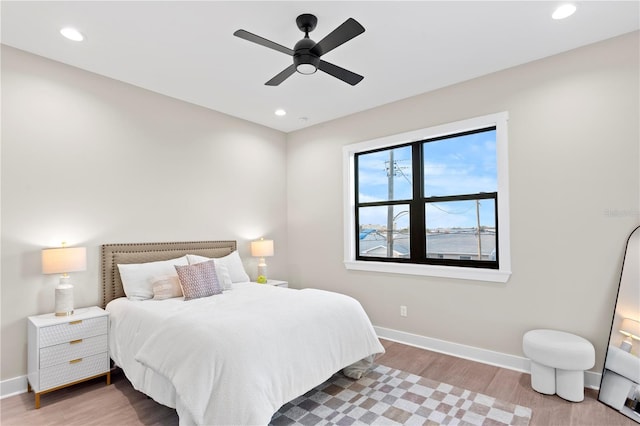 bedroom featuring baseboards, wood finished floors, and recessed lighting