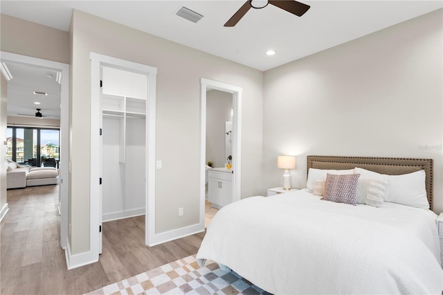 bedroom with visible vents, baseboards, light wood-style floors, a spacious closet, and a closet