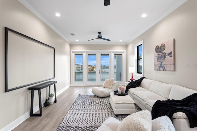 home theater room featuring light wood-style floors, recessed lighting, crown molding, and baseboards