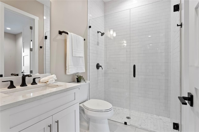 bathroom with toilet, a shower stall, and vanity