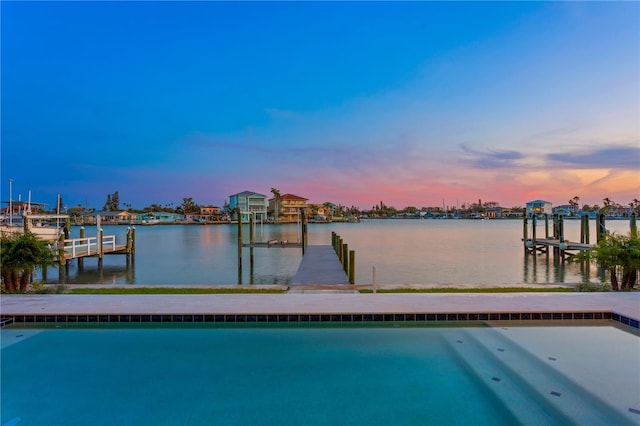 view of swimming pool featuring a dock and a water view