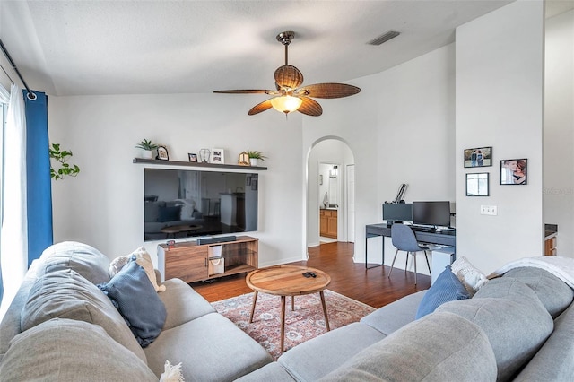 living room with lofted ceiling, ceiling fan, hardwood / wood-style floors, and a textured ceiling