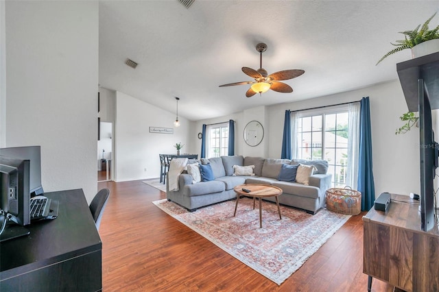 living room with ceiling fan, dark wood-type flooring, and lofted ceiling