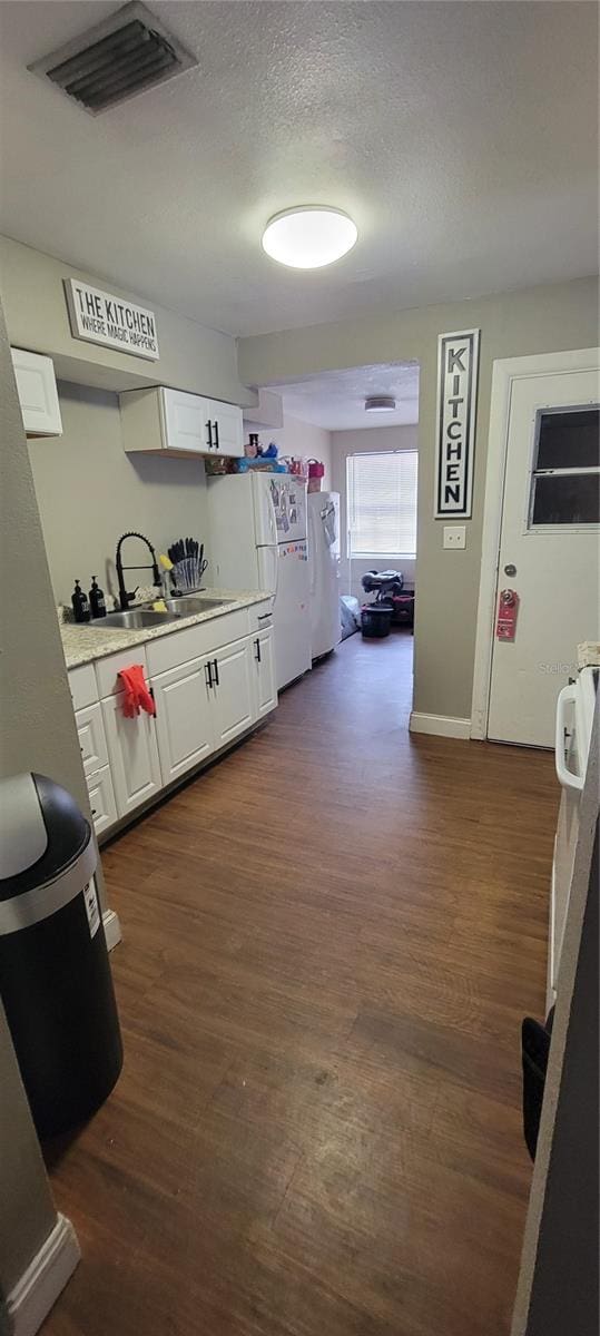 kitchen with white cabinetry, sink, dark wood-type flooring, and white refrigerator