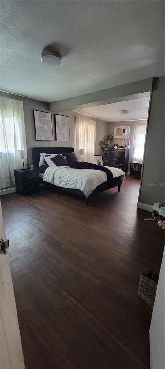 unfurnished bedroom with dark wood-type flooring and a textured ceiling